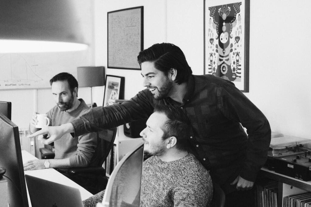 Black and white photo of a group of team members working on a project in an office