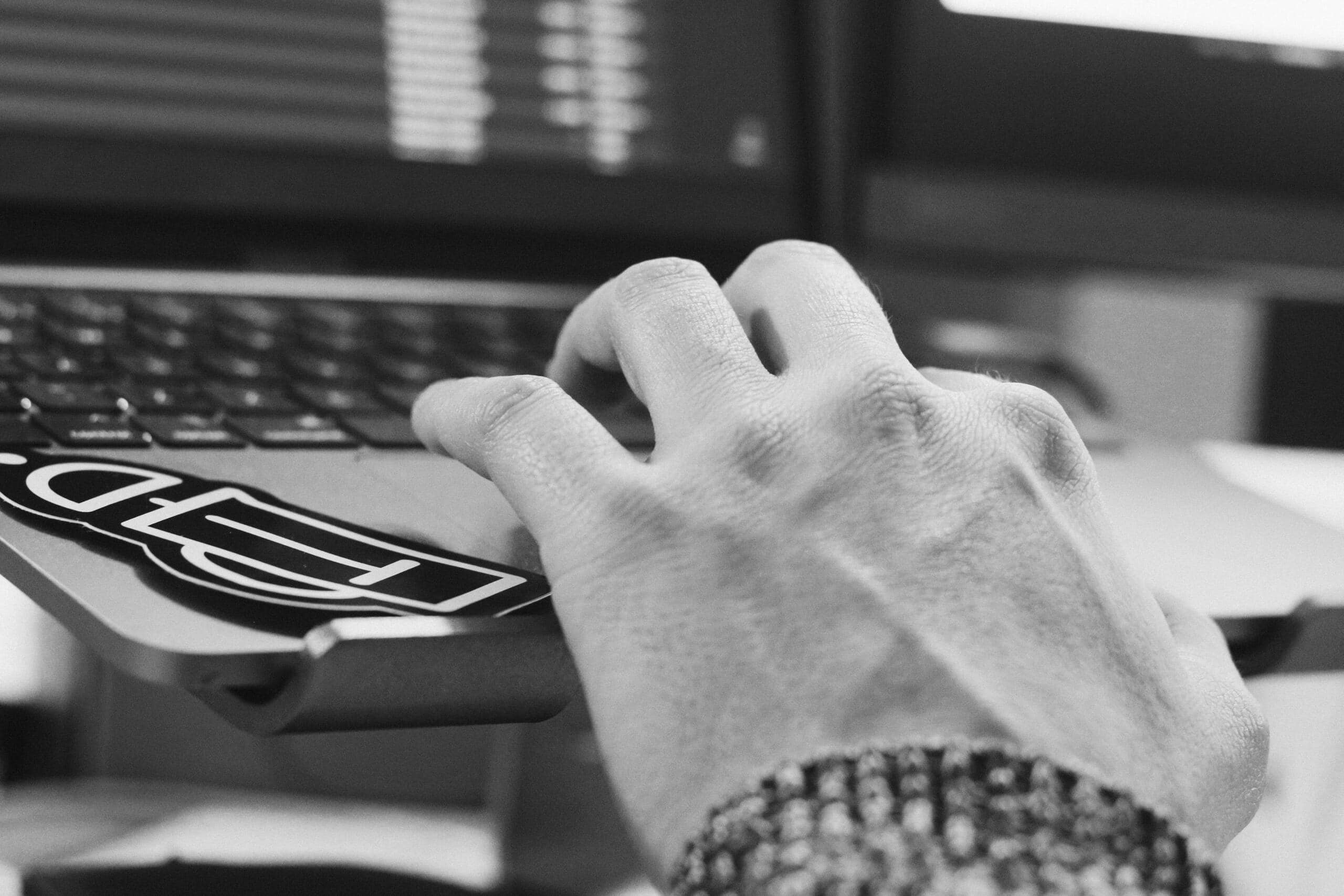 Close-up image of a hand working on a laptop